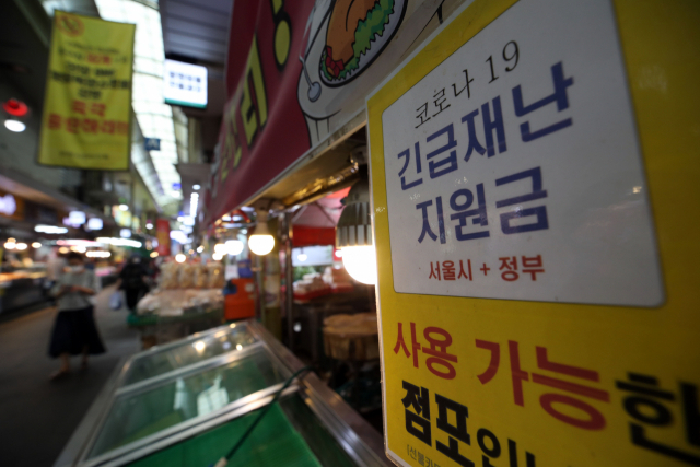 30일 서울의 한 전통 시장 가게에 긴급재난지원금을 사용할 수 있다는 안내문이 붙어 있다. 정부는 내달 6일부터 전 국민의 약 88%가 1인당 25만 원씩 받는 코로나 상생 국민지원금(재난지원금)을 지급한다./연합뉴스