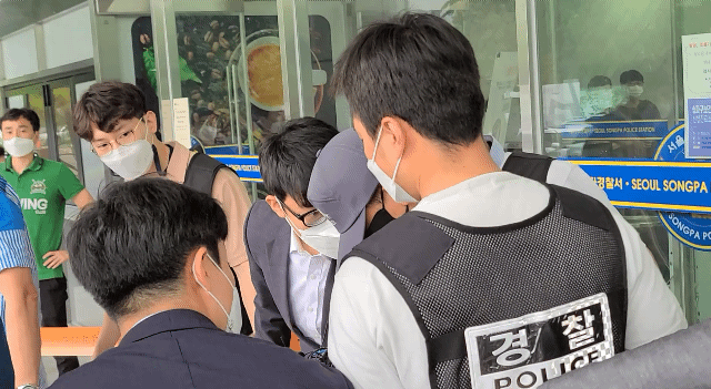 30일 서울 송파경찰서 입구에서 강씨가 호송차에 타는 중 취재진을 밀치고 있다./허진 기자
