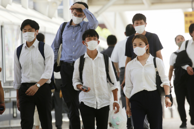 도쿄올림픽 15일째인 6일 일본 도쿄의 한 기차역에서 마스크를 쓴 시민들이 걸어가고 있다. /AP연합뉴스