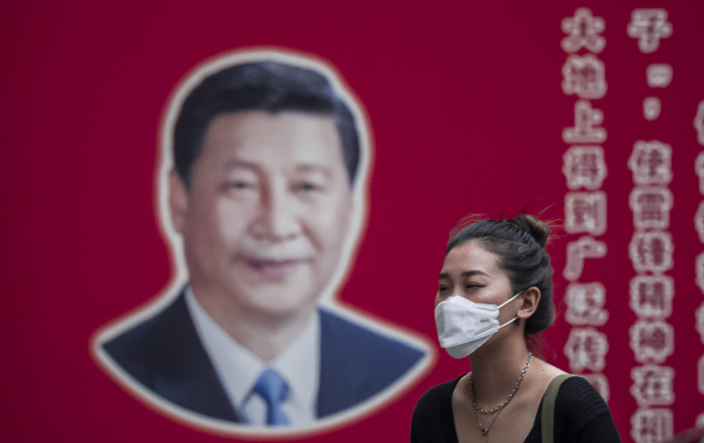 중국 상하이 거리의 시진핑 선전 홍보판 앞으로 한 시민이 마스크를 쓴 채 지나가고 있다. /EPA연합뉴스