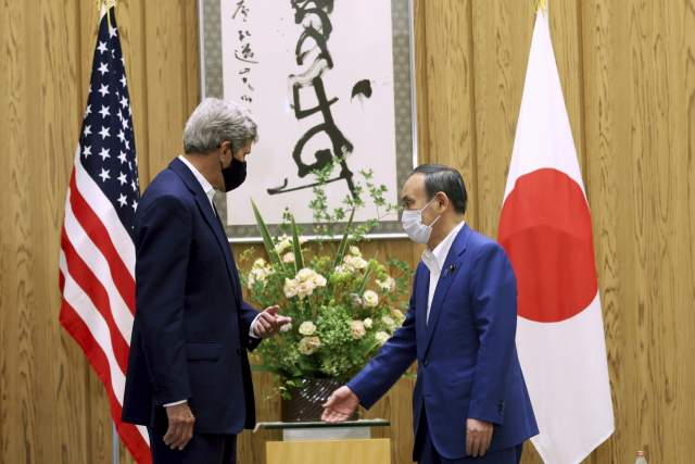 스가 요시히데(오른쪽) 일본 총리가 31일 도쿄의 총리공관에서 방일한 존 캐리 미국 기후특사와 인사하고 있다. /AP연합뉴스