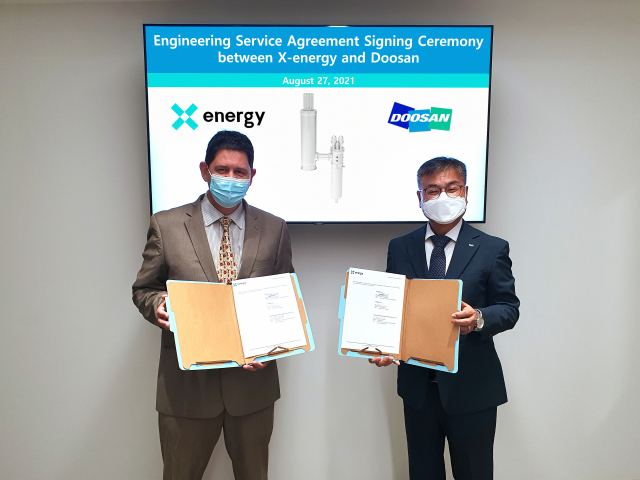 마틴 반 스테든(왼쪽) 엑스-에너지 부사장과 김종두 두산중공업 상무가 미국 매릴랜드주 록빌시 엑스-에너지(X-energy) 본사에서 계약 서명식을 하고 있다./사진 제공=두산중공업