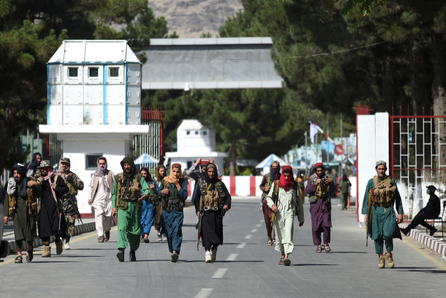 아프가니스탄 탈레반 반군 전사들이 28일(현지시간) 카불 국제공항 정문 주변을 걸어가고 있다. /AFP연합뉴스