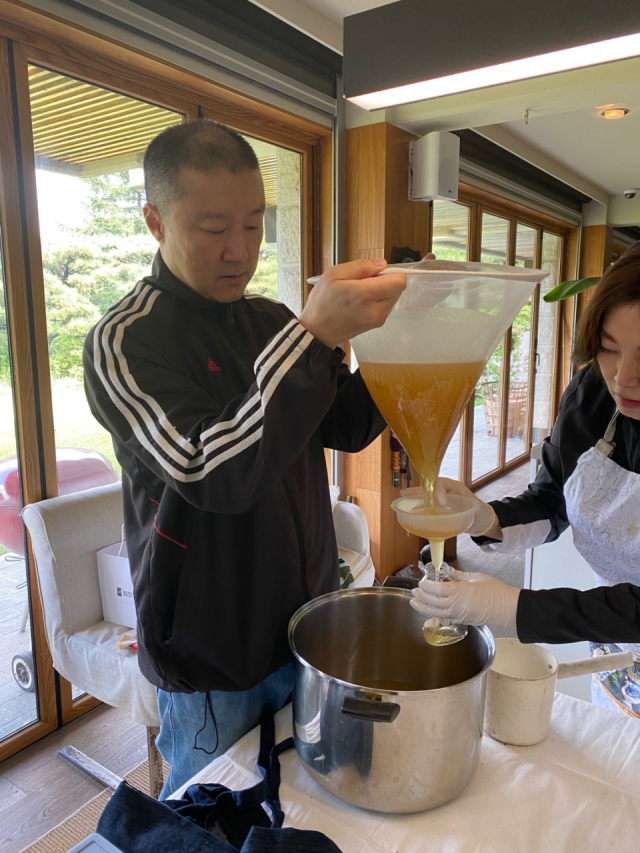 구자은 LS엠트론 회장이 서울 성북구 자택 뒤뜰에서 양봉을 통해 수확한 벌꿀을 용기에 담고 있다./사진제공=LS