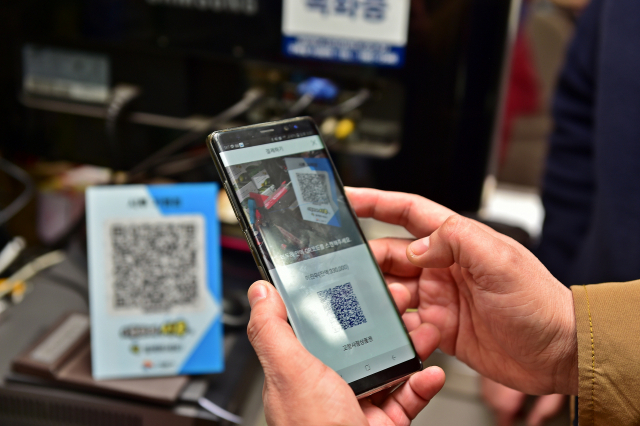 조폐공사가 구축한 스마트폰 앱(App) ‘지역상품권 chak(착)’ 을 살펴보고 있다. 사진제공=한국조폐공사