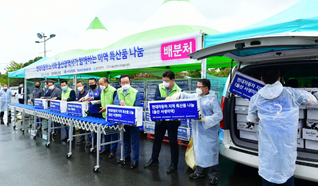 송철호 울산시장과 이동석 현대자동차 부사장, 최정식 노조 부지부장 등이 3일 울산 동천체육관에서 미역 특산품을 구매해 사회복지센터 등에 전달하고 있다. /사진제공=현대자동차