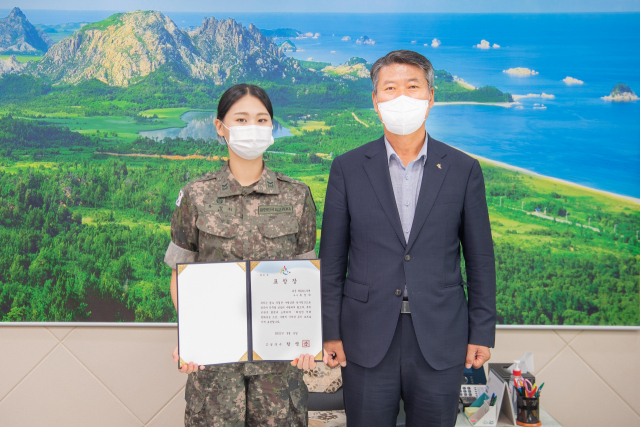 6일 함명준 강원 고성군수가 쌍호여단 응급구조부사관 류정하 하사를 초청해 표창을 수여한 뒤 기념 촬영하고 있다. /연합뉴스