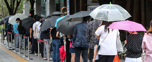 7일 오전 서울 송파구 송파구보건소 선별진료소에서 시민들이 우산을 들고 신종 코로나바이러스 감염증 검사를 받기 위해 대기하고 있다./연합뉴스