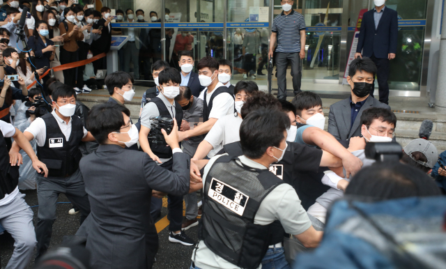 7일 오전 송파경찰서에서 여성 2명 살해 혐의로 이송되는 강윤성에게 유가족으로 보이는 한 남성(오른쪽 모자 쓴 사람)이 달려들자 경찰이 제지하고 있다. 송파경찰서는 이날 강씨를 서울동부지검에 송치했다./연합뉴스