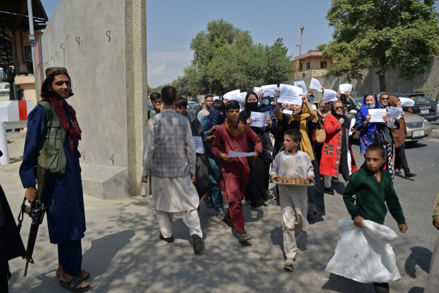 아프가니스탄 수도 카불에서 지난 3일(현지시간) 총을 든 탈레반 대원 앞에서 여성 시위대가 교육과 취업 등 권리 보장을 요구하며 거리 행진을 벌이고 있다. 현지 언론은 수도 카불 등지에서 여성 시위가 확산하자 탈레반은 최루탄과 공포탄을 쏘며 시위대를 해산하는 등 적극 대응에 나섰다고 전했다. /연합뉴스