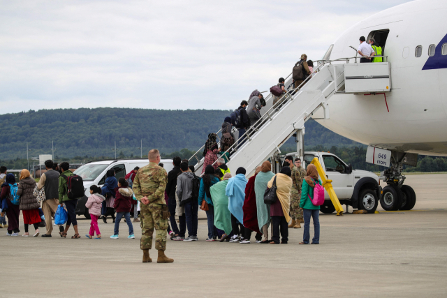 독일 람슈타인 미국 공군기지에 최근 임시 수용됐던 아프가니스탄 피란민들이 지난달 26일(현지시간) 기지 내에 대기 중인 미국행 비행기에 오르고 있다. /AFP연합뉴스