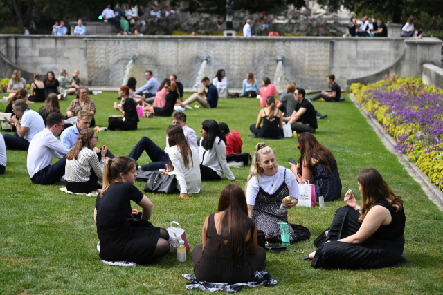 6일(현지 시간) 영국 런던의 한 공원에서 사람들이 마스크를 쓰지 않은 채 잔디밭에 앉아 대화를 나누고 있다./AFP연합뉴스