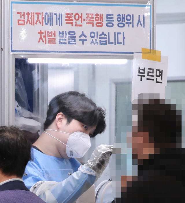 보건소 선별진료소에서 관계자가 PCR 검사를 하고 있다./연합뉴스