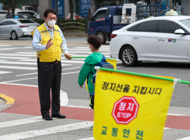 국민의힘 대권 주자인 윤석열 전 검찰총장이 국민의힘 1차 경선 일정인 봉사활동을 수행하기 위해 9일 서울 상계동 노일초등학교 인근 횡단보도에서 교통봉사를 하고 있다./사진=윤석열 캠프 제공