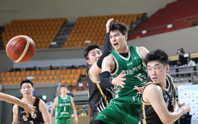 원주 DB 김종규(오른쪽 두 번째)가 13일 경북 상주에서 열린 프로농구 KBL 컵대회 C조 경기에서 상무 선수들과 공을 다투고 있다. DB가 86 대 84로 이겼다. /연합뉴스