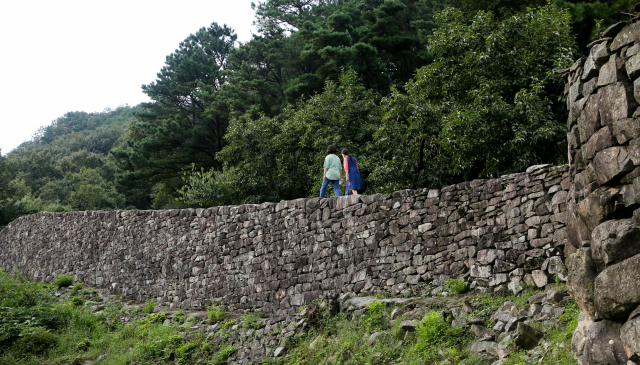 위봉산성 서문 옆으로 이어진 산성을 따라 여행객들이 여유롭게 걷고 있다.
