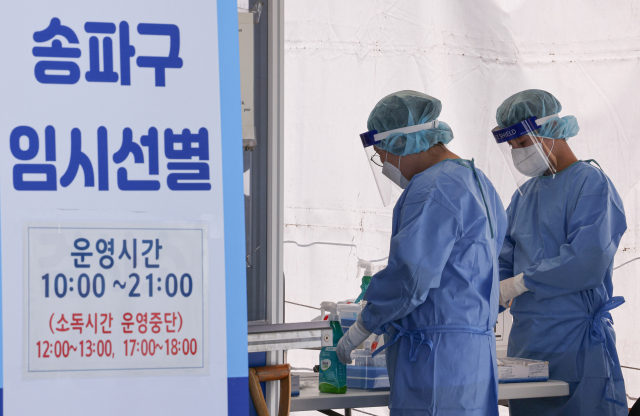 16일 오전 서울 송파구 올림픽 공원에 설치된 송파구 신종 코로나바이러스 감염증(코로나19) 임시 선별진료소에 의료진이 분주하게 PCR 검사를 시행하고 있다./연합뉴스