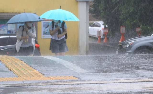 지난 16일 오후 제주 서귀포여고 학생들이 우산을 쓰고 학교를 나서고 있다./제주=연합뉴스