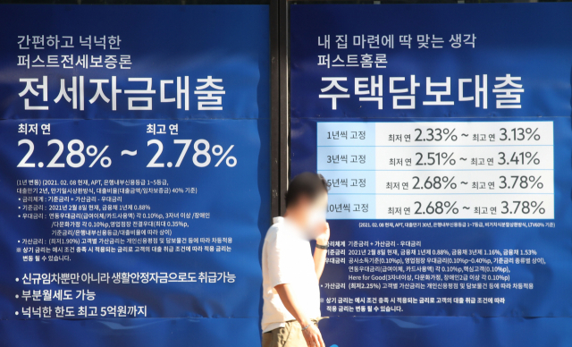 지난 8일 서울 시내 한 시중은행 앞에 게시된 대출 광고 앞으로 한 시민이 걸어가고 있다./연합뉴스