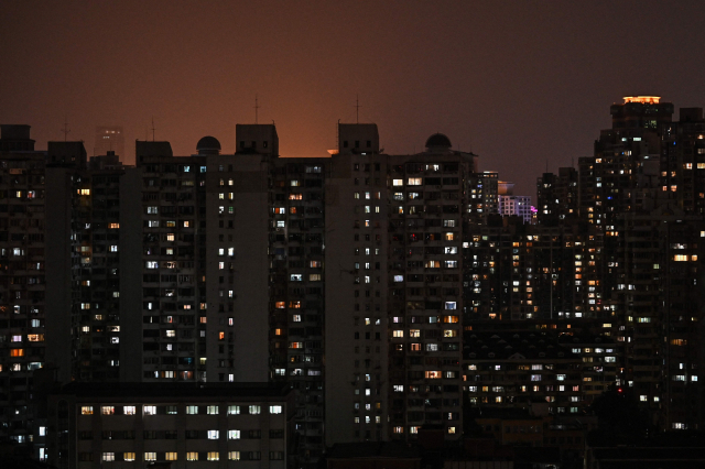 중국이 최근 심각한 전력난을 겪고 있는 가운데 지난 27일 밤 최대 경제 도시 상하이의 주거용 빌딩들이 불을 밝히고 있다. 중국 국가전력망공사 상하이지사는 이날부터 10월 3일까지 '특정 시기, 특정 지역'에서 정전을 한다고 이날 공지했다./AFP연합뉴스