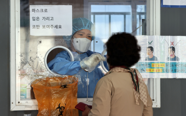 코로나19 임시 선별검사소에서 의료진이 검체를 채취하고 있다. /연합뉴스