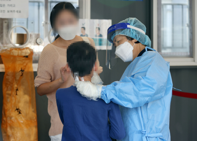 지난 3일 서울역광장에 마련된 신종 코로나바이러스 감염증(코로나19) 임시 선별검사소에서 한 어린이가 검사를 받고 있다./연합뉴스