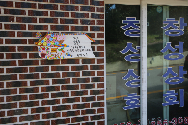 성안마을 상점 앞에 정감 어린 글귀가 적힌 팻말이 붙어 있다.