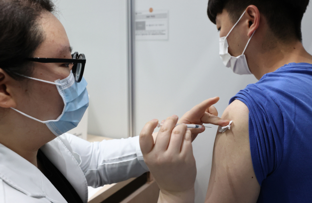 6일 오전 서울 마포구민체육센터에 마련된 코로나19 예방접종센터를 찾은 시민이 백신을 접종하고 있다./연합뉴스