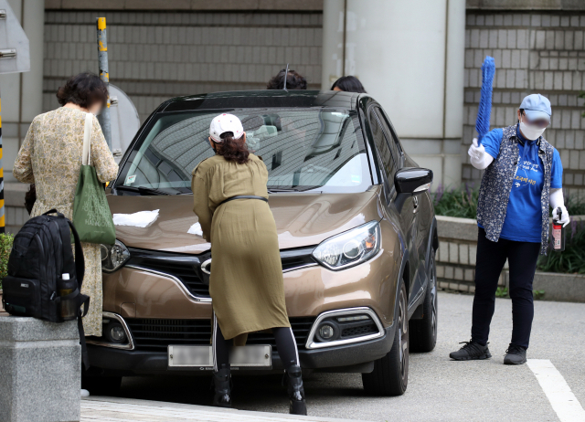 지난달 10일 지지자들이 조 전 장관이 타고 온 차를 닦아주고 있다. /연합뉴스