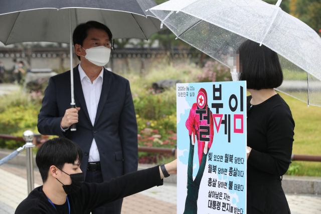 안철수 국민의당 대표가 8일 오후 서울 청와대 분수대 앞에서 1인 시위를 하고 있는 북 피격 해수부 공무원 유족을 만나 대화하고 있다. /연합뉴스