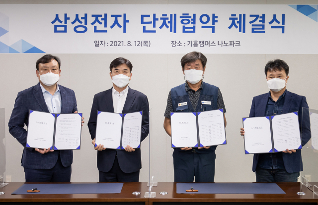 지난 8월 12일 경기도 용인 기흥캠퍼스 나노파크에서 단체협약을 체결한 삼성전자 노사 관계자들이 협약서를 펼쳐 보이고 있다./사진=삼성전자