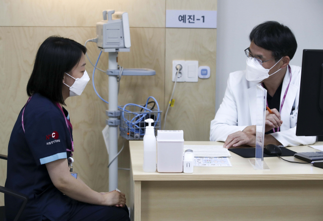 12일 오후 서울 중구 국립중앙의료원 중앙예방접종센터에서 치료병원 종사자가 백신 접종을 받기 전 예진을 받고 있다. /이호재 기자