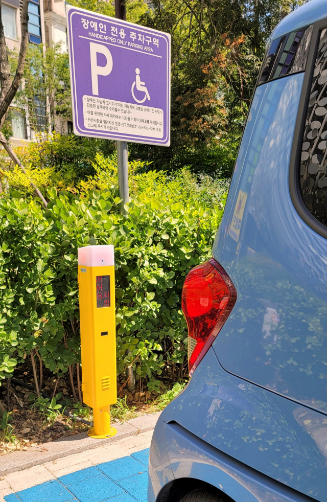 차량 번호를 인식해 장애인 등록 여부를 확인하는 노란색 기둥 모양의 판독 기기가 장애인주차구역에 설치돼 있다. /사진 제공=서대문구