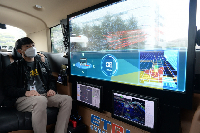 지난 6월 ETRI 연구진이 개발한 자율주행 셔틀버스 '오토비' 내 투명 OLED 디스플레이로 AR 실감 가이드 기술을 시연하고 있다./사진제공=LG디스플레이