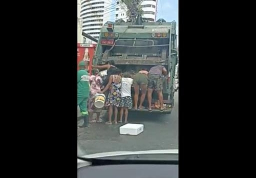 쓰레기 수거 트럭에 매달려 식료품을 뒤지는 브라질 주민들. /브라질 글로부 TV 캡처.