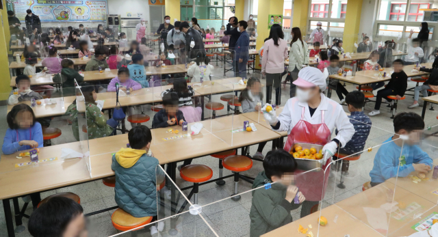 학교에서 급식, 돌봄 등의 업무를 하는 교육공무직 노동자들이 총파업에 나선 20일 서울 시내 한 초등학교에서 학생들이 대체 메뉴로 준비된 샌드위치와 쥬스를 먹고 있다. /연합뉴스
