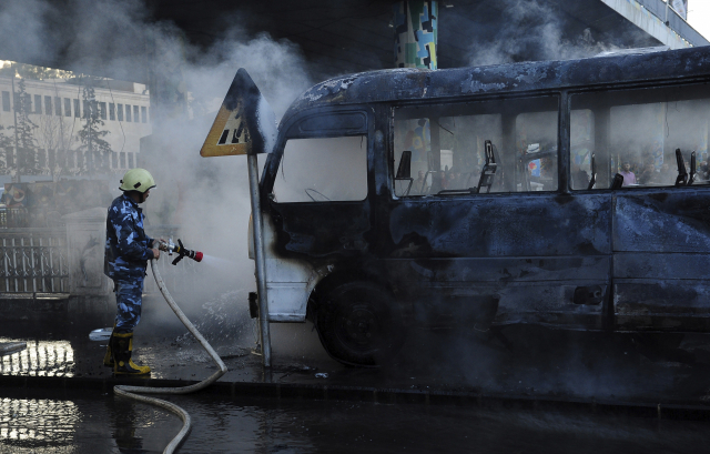 지난 20일(현지시간) 시리아 수도 다마스쿠스 중심가에서 발생한 군용 버스 폭발 현장에서 한 소방관이 버스의 불을 끄고 있다./다마스쿠스 AP/SANA=연합뉴스