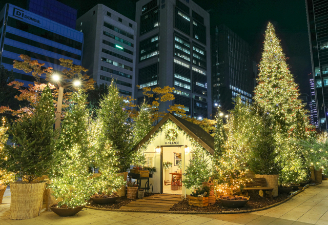 서울 강남구 현대백화점 무역센터점 정문 앞에 설치된 ‘H빌리지’로, 13m 높이의 대형 크리스마스 트리와 캐빈하우스(통나무집), 나무 120 그루가 들어섰다./사진 제공=현대백화점