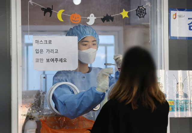 28일 서울역 광장에 마련된 코로나19 임시 선별검사소에서 의료진이 검체를 채취하고 있다./연합뉴스