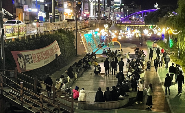 지난 22일 오후 11시 29분께 서울 관악구 도림천에 설치된 ‘하천 내 음주를 금지한다’는 내용의 현수막 아래에 음주를 즐기는 시민들이 가득하다. /이주희 인턴기자
