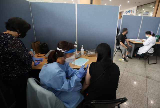 서울 송파구 가락시장에 설치된 '찾아가는 코로나19 백신접종센터'에서 상인들이 얀센 백신을 접종받고 있다./연합뉴스