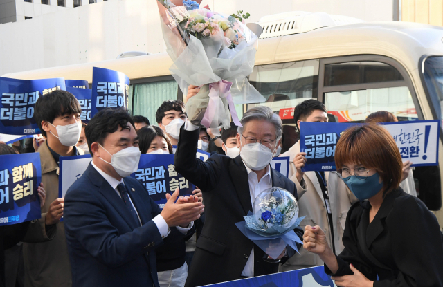 이재명 더불어민주당 대선 후보가 전날 서울 여의도 당사에서 당직자로부터 받은 꽃다발을 들어보이고 있다. /권욱 기자