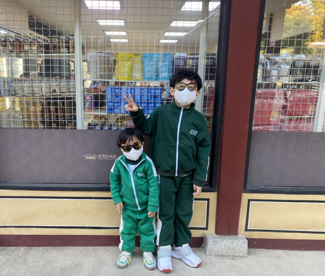 ‘오징어 게임’에 등장하는 초록색 체육복을 입고 온 한씨 자녀들의 모습. /장유하 인턴기자