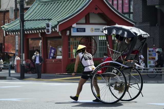 일본 도쿄의 한 거리에서 인력거꾼이 인력거를 몰고 있다. /AP연합뉴스