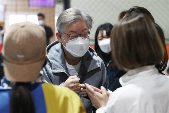 이재명 더불어민주당 대선 후보가 31일 경기 고양시 덕양구 상암농구장에서 2030 여성들과 '넷볼'(영국에서 농구를 모방해 만들어진 여성 전용 스포츠) 경기를 체험하기 전 참석자들과 주먹인사를 하고 있다. /권욱 기자