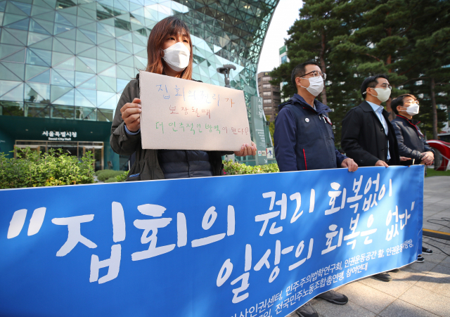 공권력감시대응팀·민주사회를위한변호사모임·참여연대 및 민주노총 관계자 등이 정부의 ‘단계적 일상 회복’ 조치 발표가 예정된 지난 29일 오전 서울시청 앞에서 기자회견을 열고 방역 조치로 크게 제한된 집회의 권리 회복을 촉구하고 있다. /연합뉴스