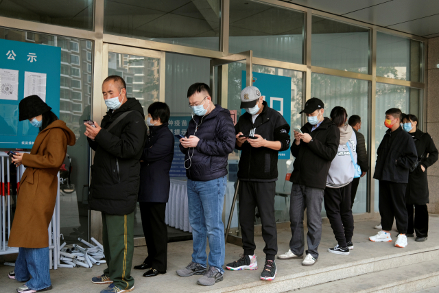 지난 29일 중국 베이징에서 코로나19 백신 부스터샷을 맞으려는 시민들이 접종소 앞에 길게 줄지어 서 있다. /연합뉴스