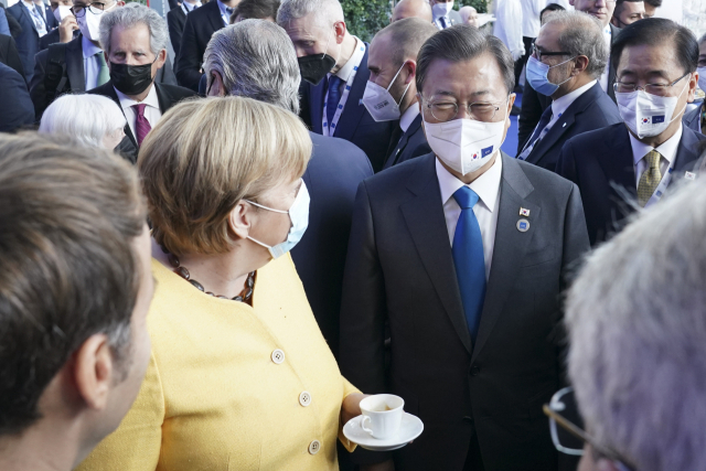 문재인 대통령이 지난 30일 이탈리아 로마 누볼라 컨벤션 센터에서 열린 주요 20개국(G20) 정상회의 정상 단체사진 촬영 전 앙겔라 메르켈 독일 총리와 만나 대화하고 있다. /로마=연합뉴스