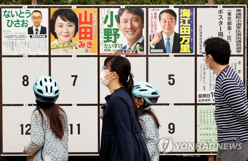 일본 중의원 총선 투표일인 10월 31일 수도 도쿄의 투표소 밖에서 한 유권자가 선거 벽보를 살펴보고 있다./로이터연합뉴스