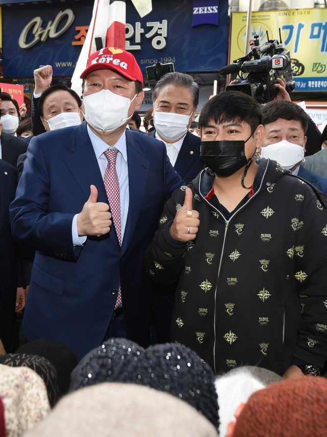 윤석열 국민의힘 대선 경선 후보가 3일 오전 서울 중구 남대문시장을 방문해 모자를 구입한 뒤 기념촬영을 하고 있다/국회사진기자단 2021.11.03